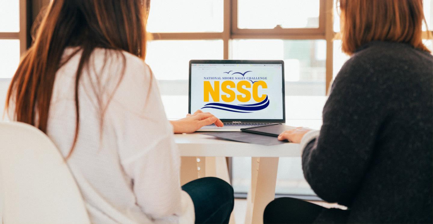 women in front of laptop with NSSC Logo