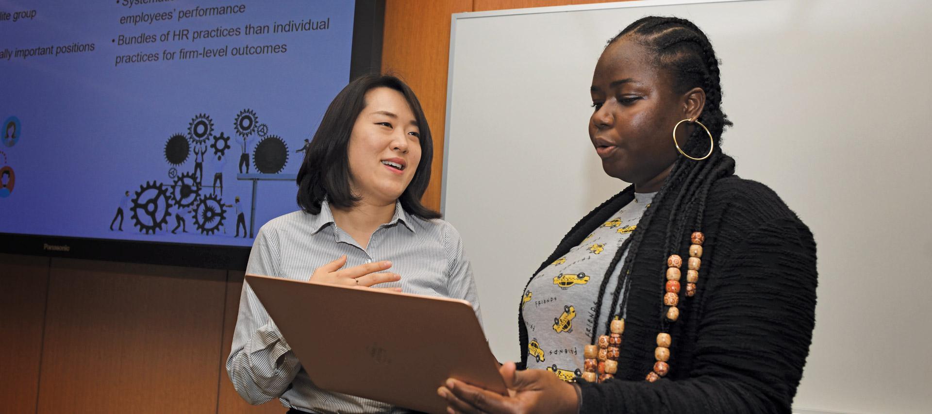 Professor speaking with a student in classroom