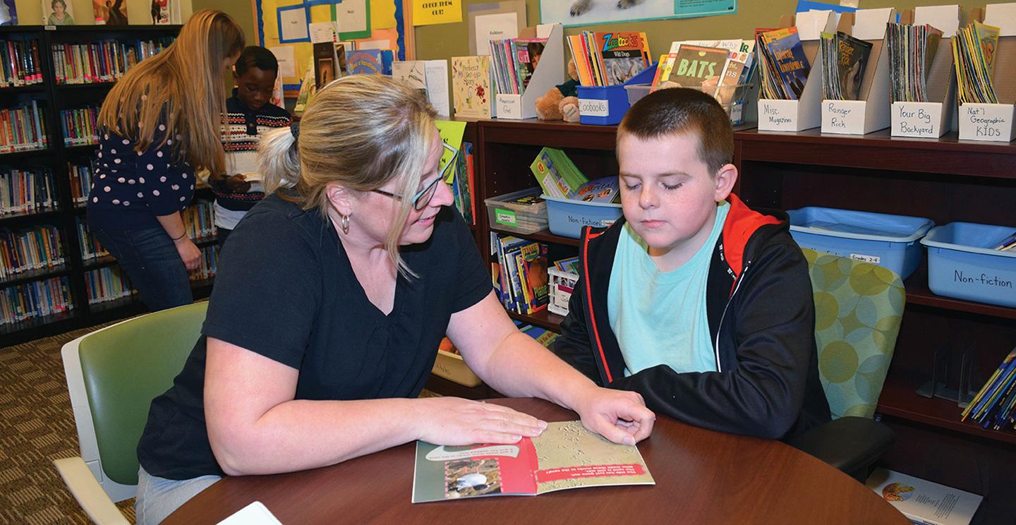 A doctorate student in the Salisbury University education department helps a child read