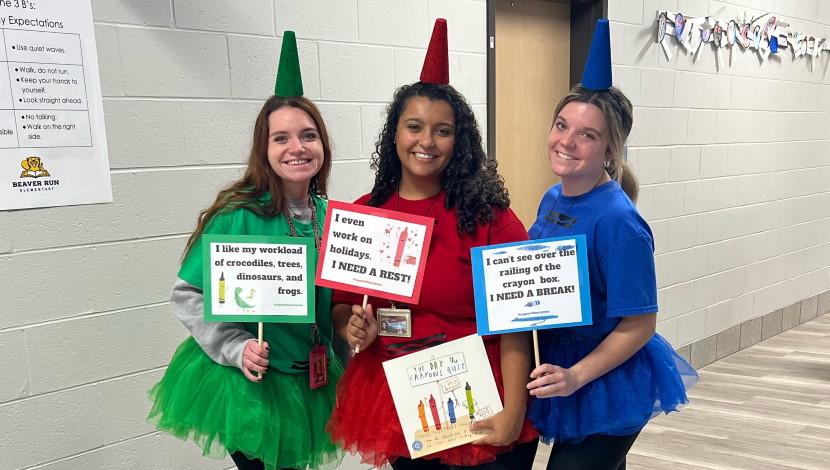 Three teachers pose for picture in costumes