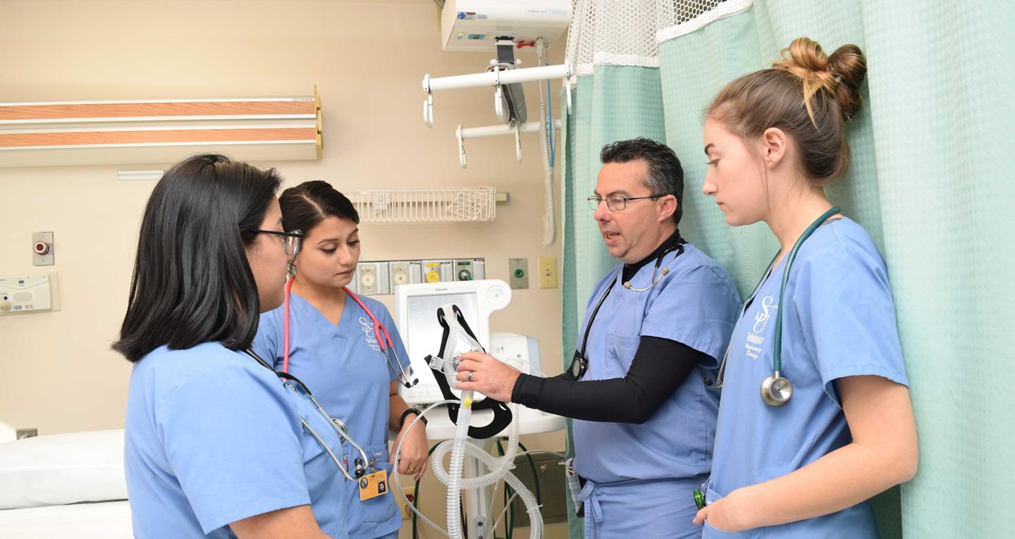 instructor showing students equipment in sim center