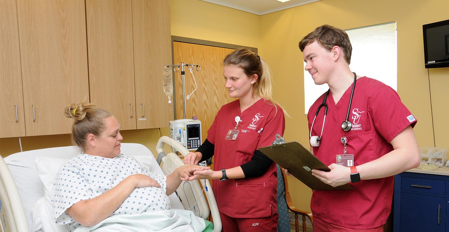 Two Salisbury University Students work with a pregnant patient 