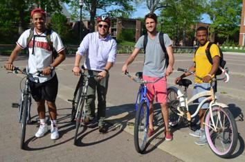 4 students pose on bikes