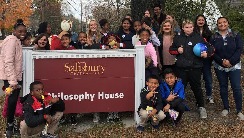 Students by the Philosophy House sign