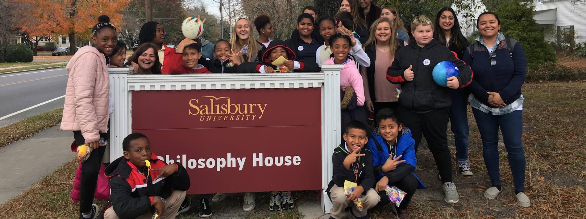 Students by the Philosophy House sign
