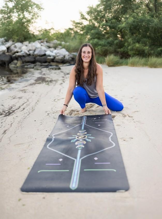 Woman with yoga mat on the beach