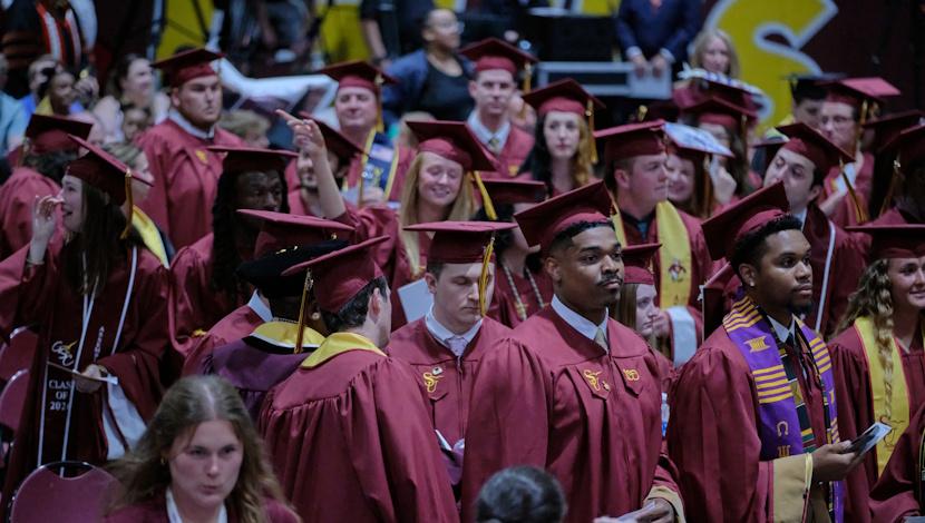 Graduates walking past stadium seats