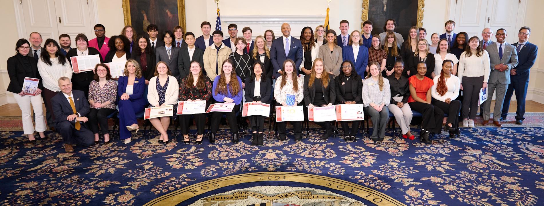 Group photo of students and legislators at Poster on the Bay