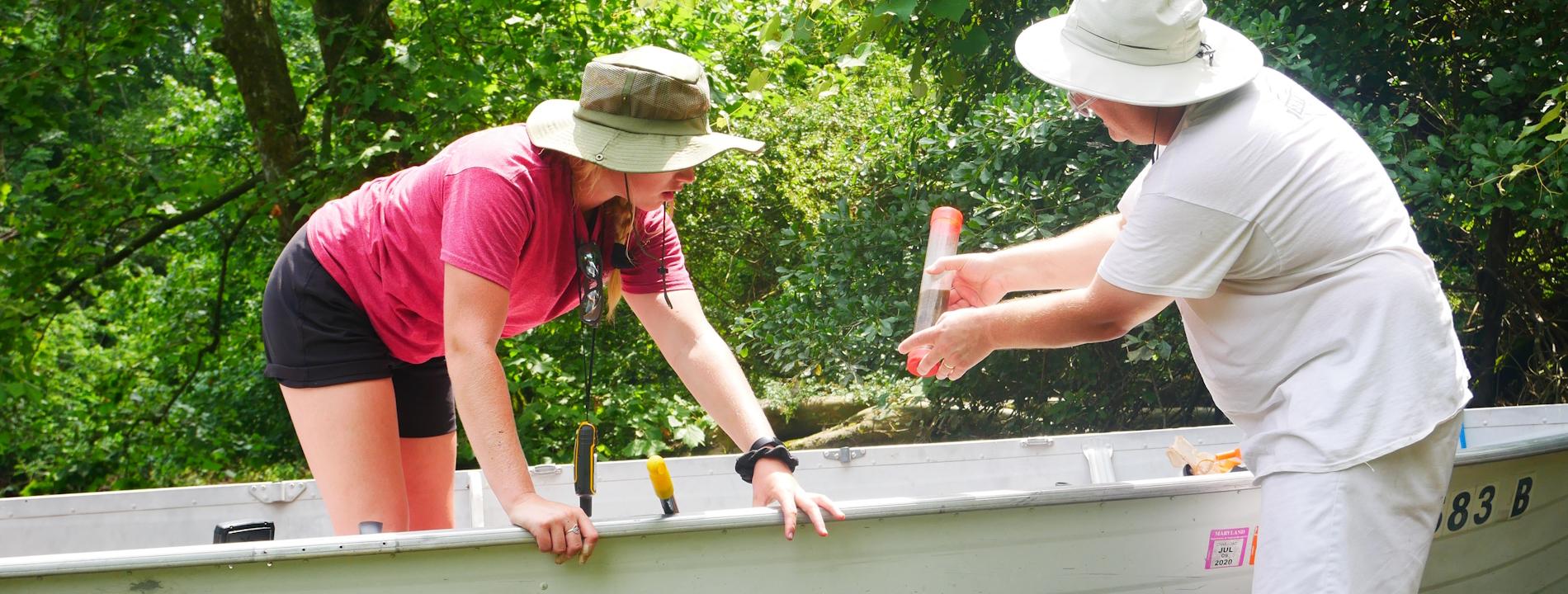 Student and professor in shallow water conducting research
