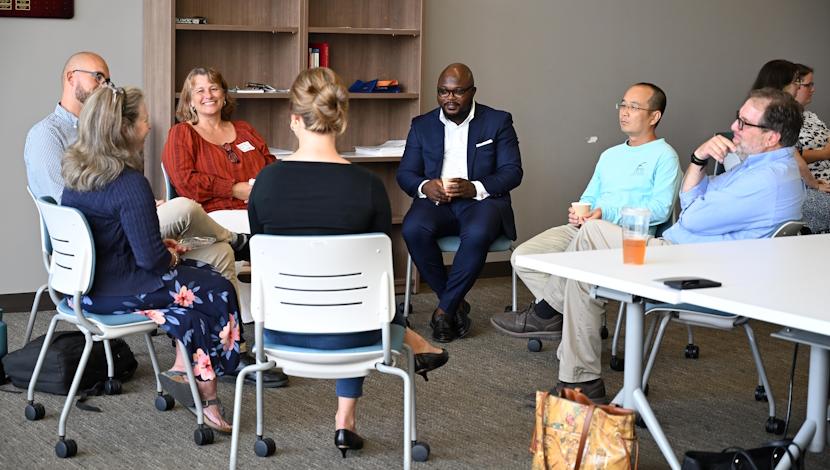 Faculty sit in circle talk