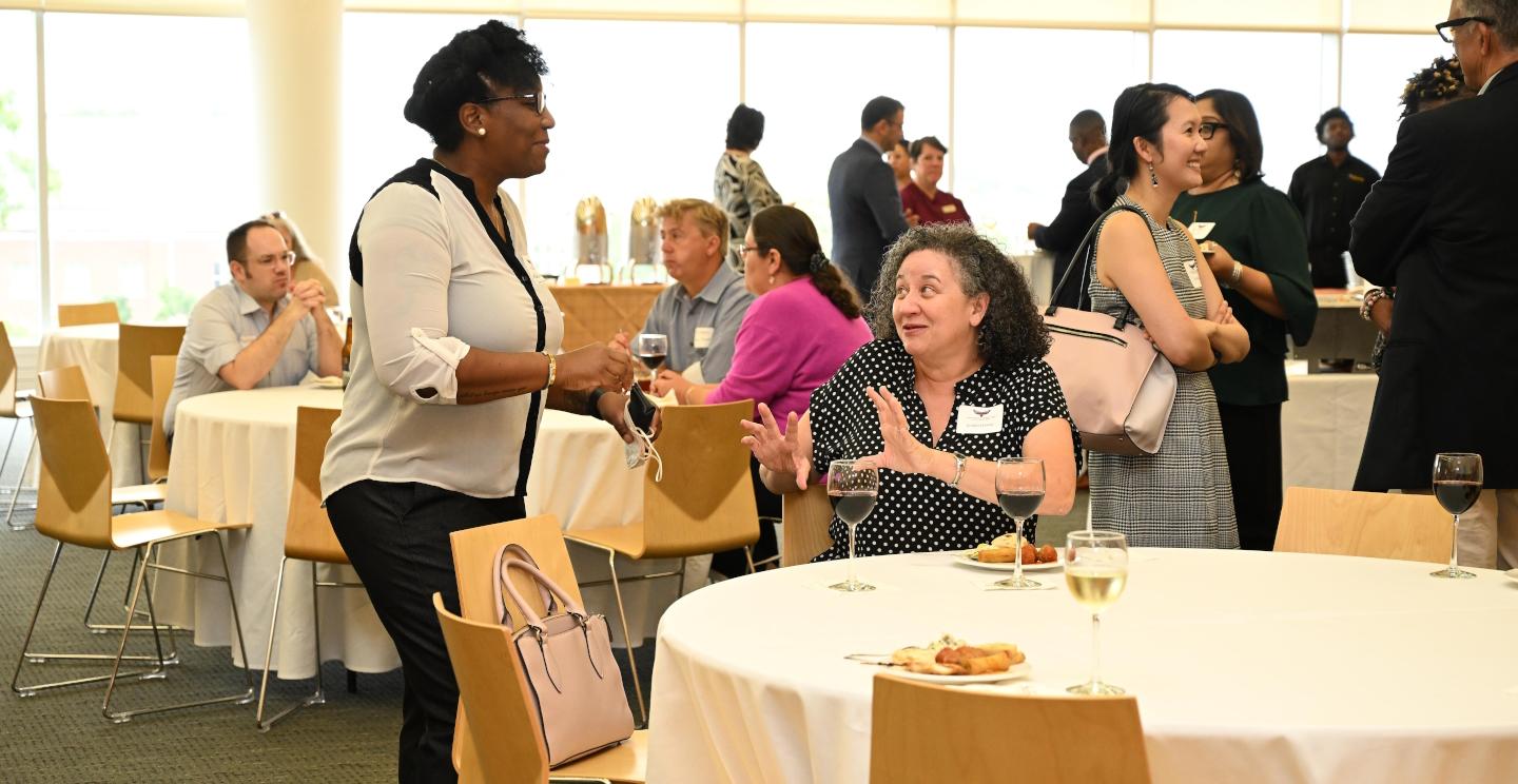 Two faculty members talk at an event