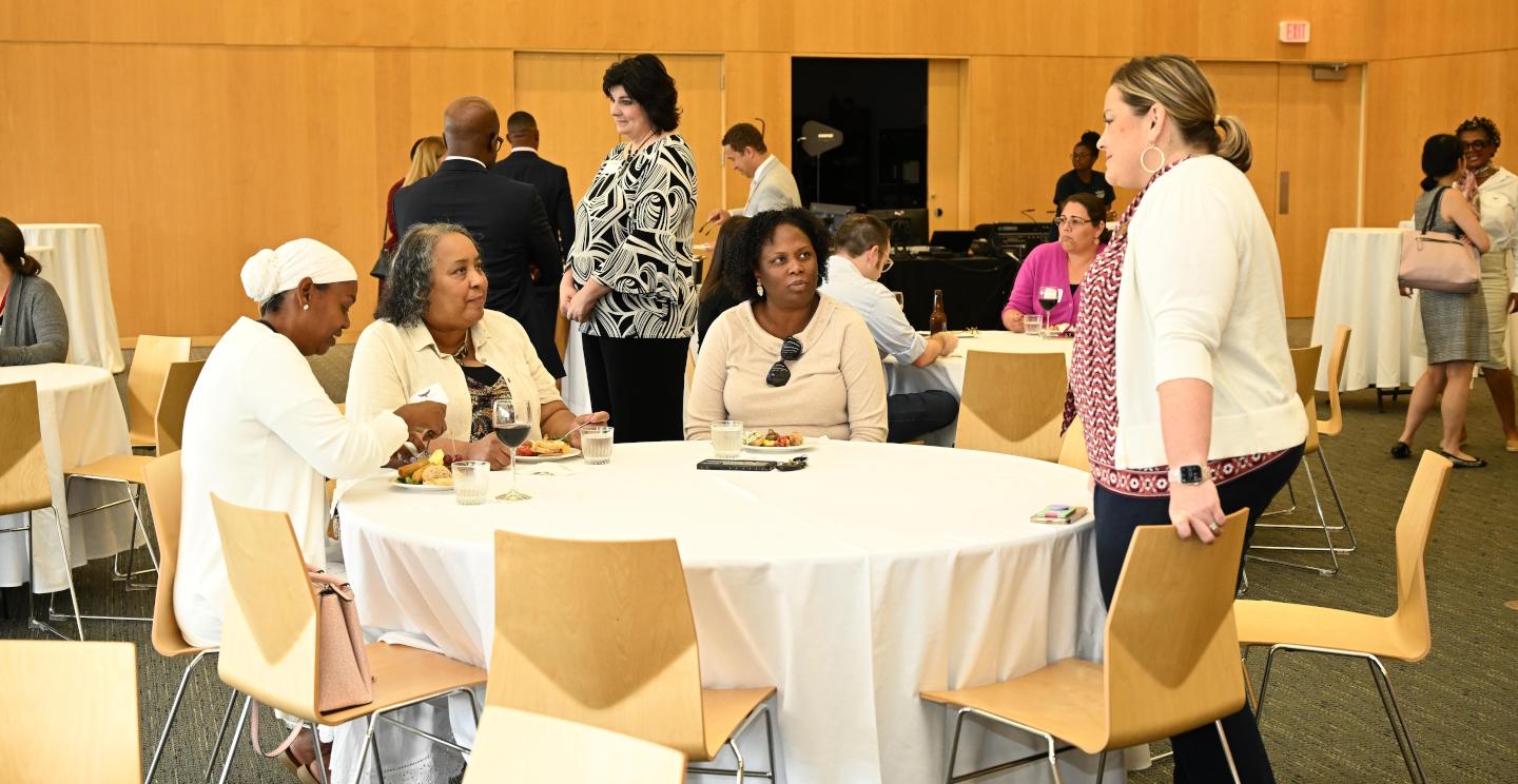 Group of faculty talk at a round table