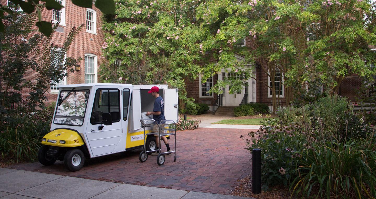 student worker loading mail truck outside holloway hall