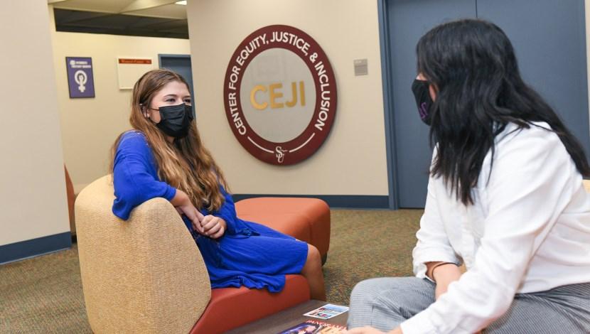 Two students talk at a a conversation lounge in the Center for Equity Justice & Inclusion