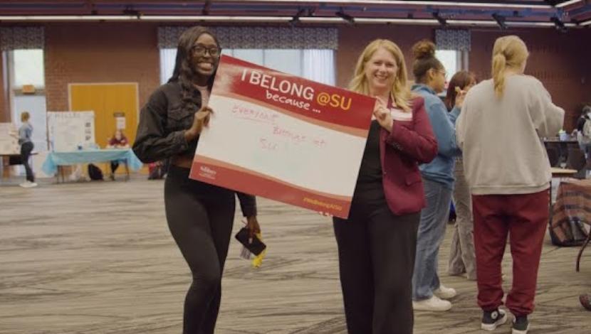 President Lepre with a student hold a sign