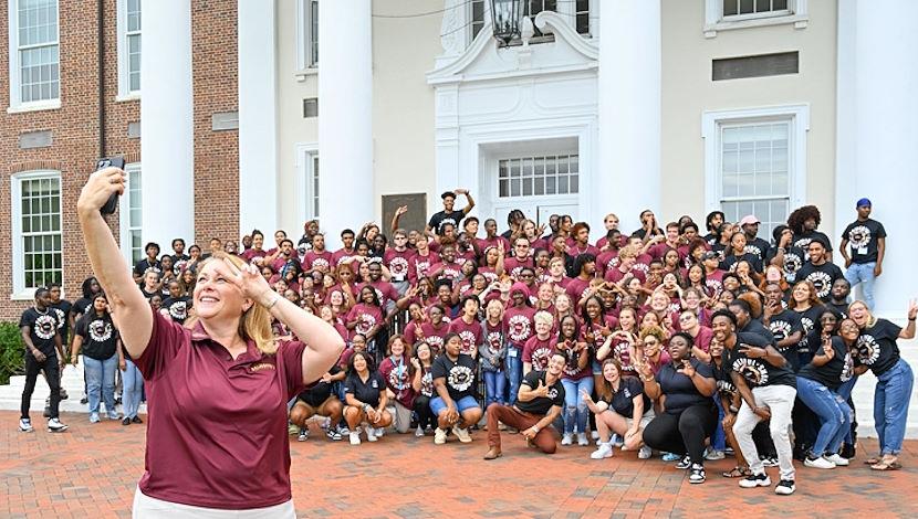 Students on steps of Holloway Hall while President Lepre takes a selfie