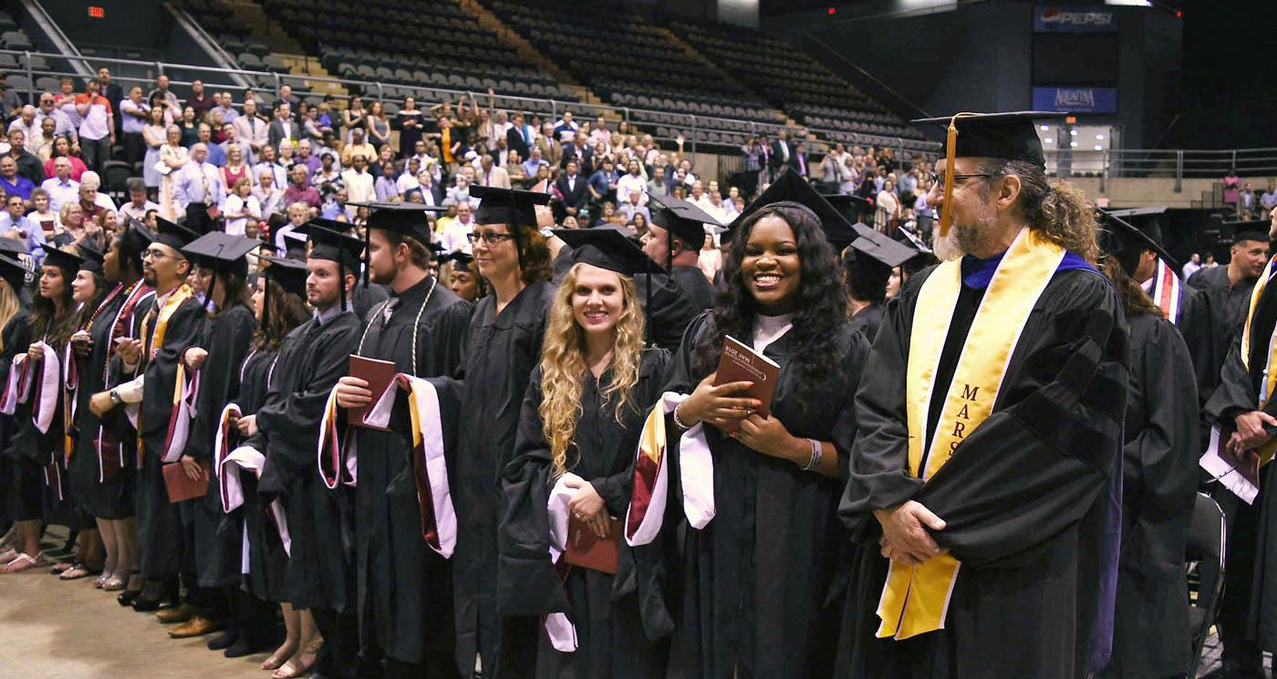 ˶graduate students at evening commencement earn masters and doctoral degrees