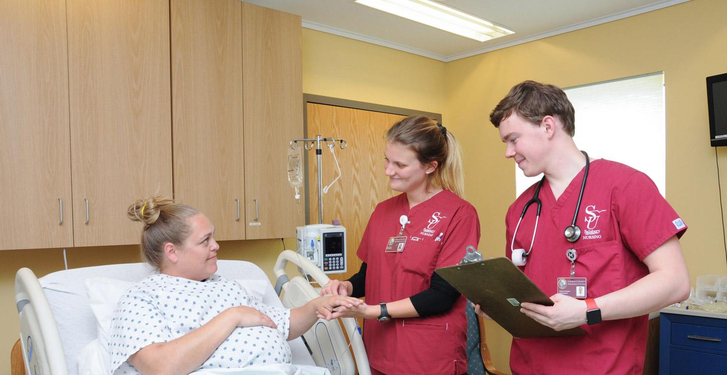 nursing students helping patient at SIM center