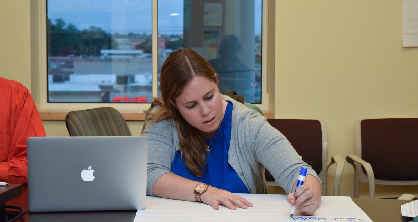 student pursuing a masters in curriculum and instruction writing at a desk