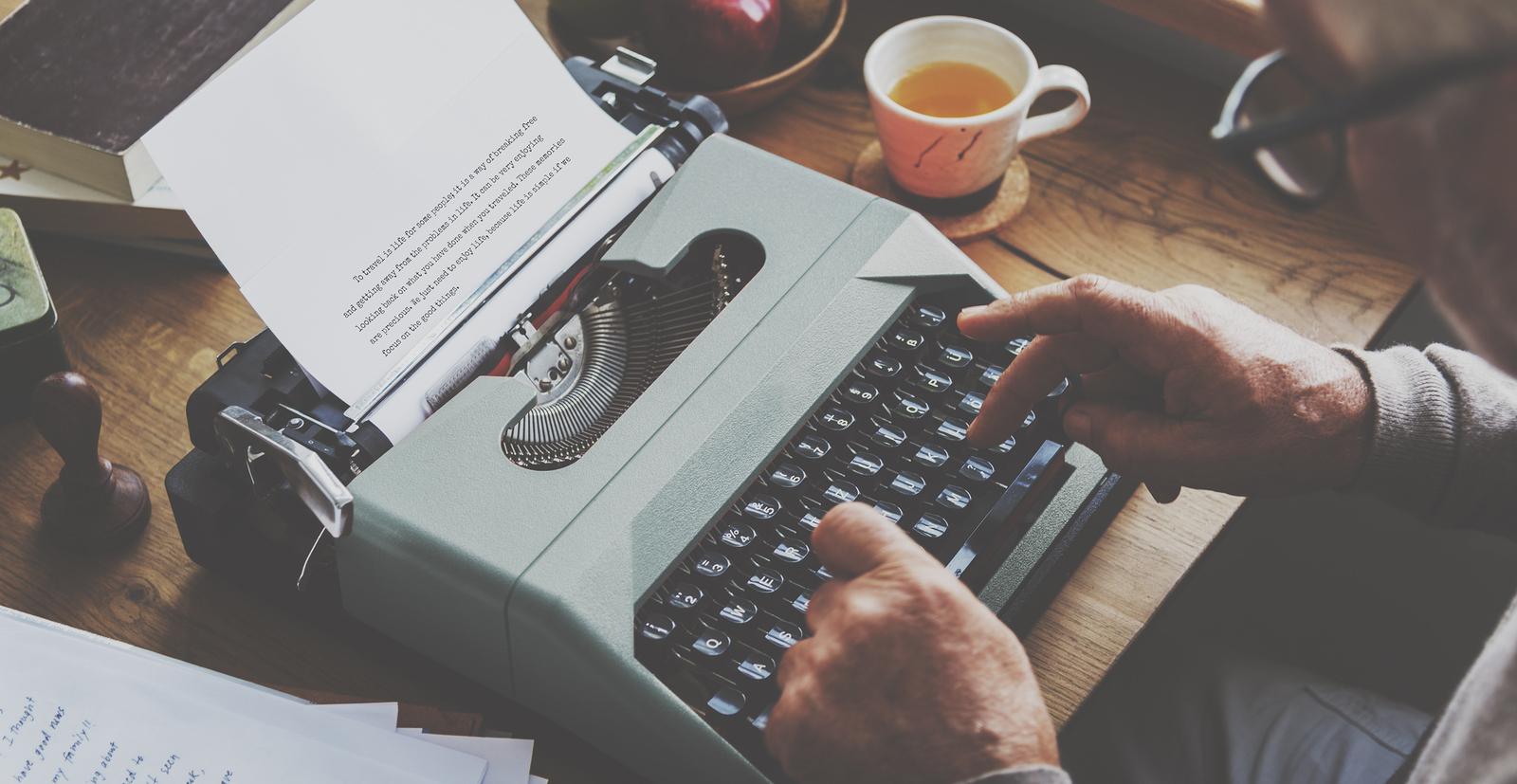 Master of Arts in English student works on a typewriter.