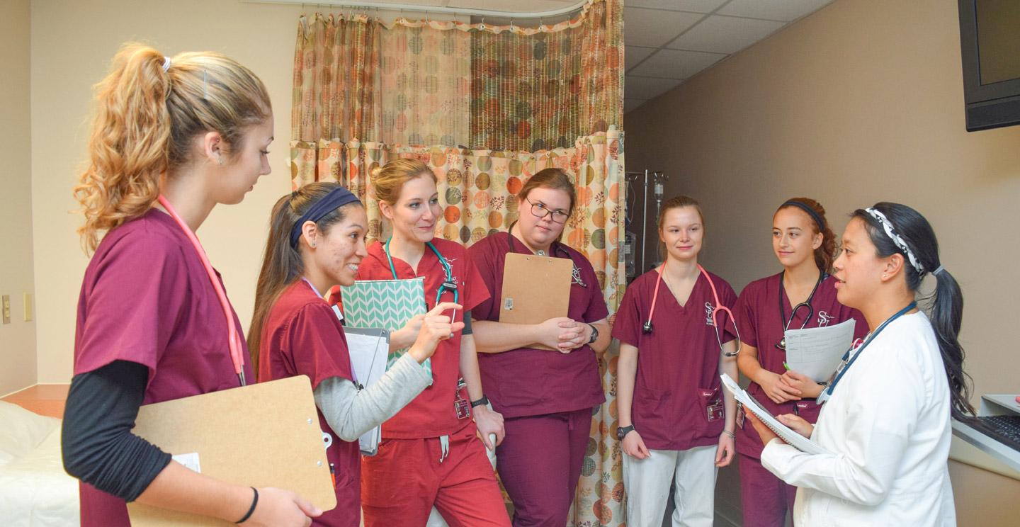 group of nursing majors listening to instruction at SIM center
