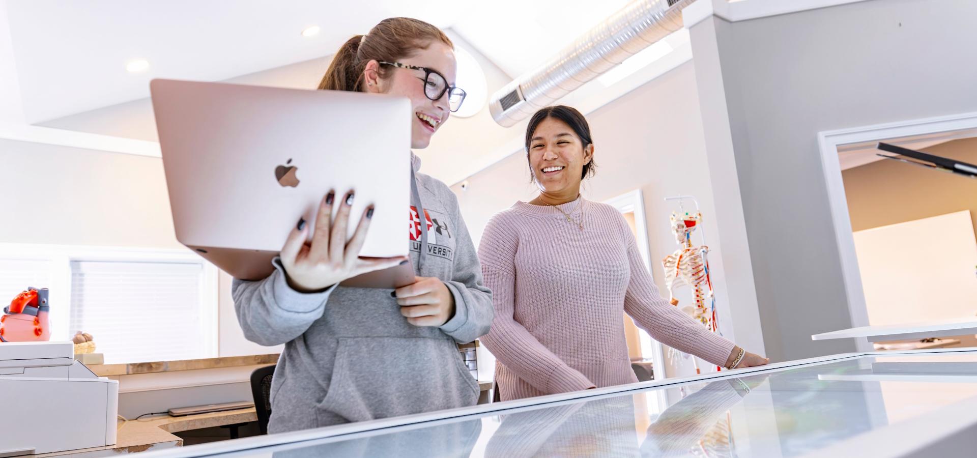 Two Health Communication Minor students work in a lab