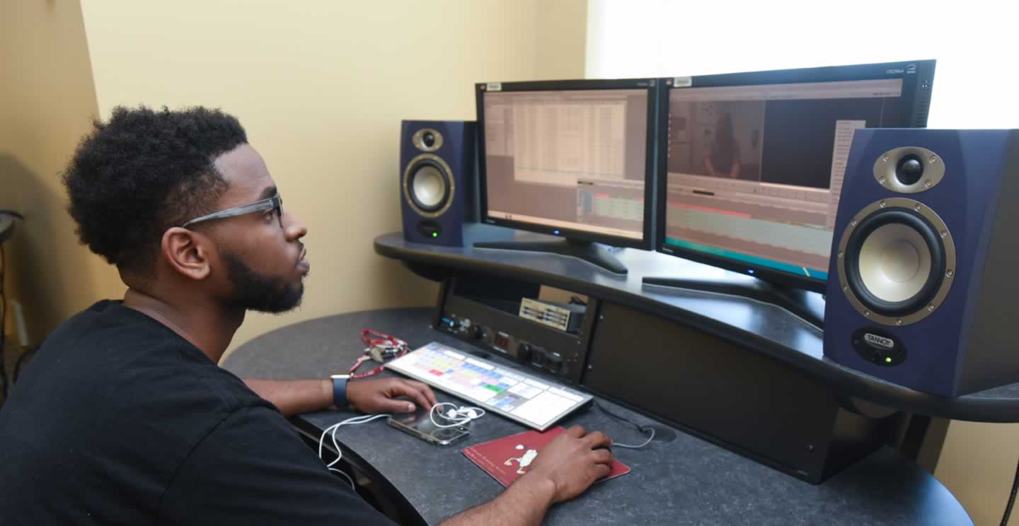 student working on computer with multiple monitors