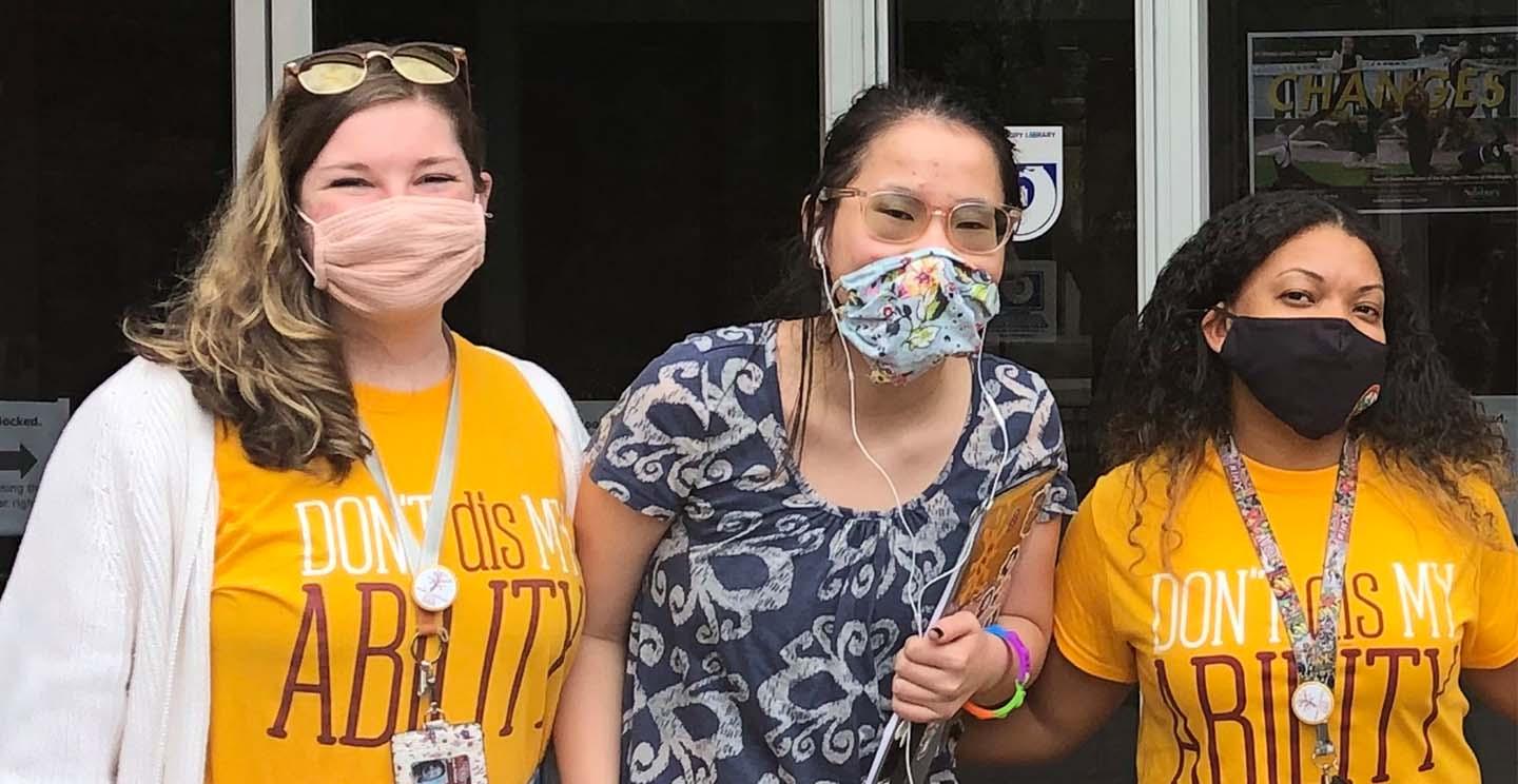 Two students on campus outside using sign language