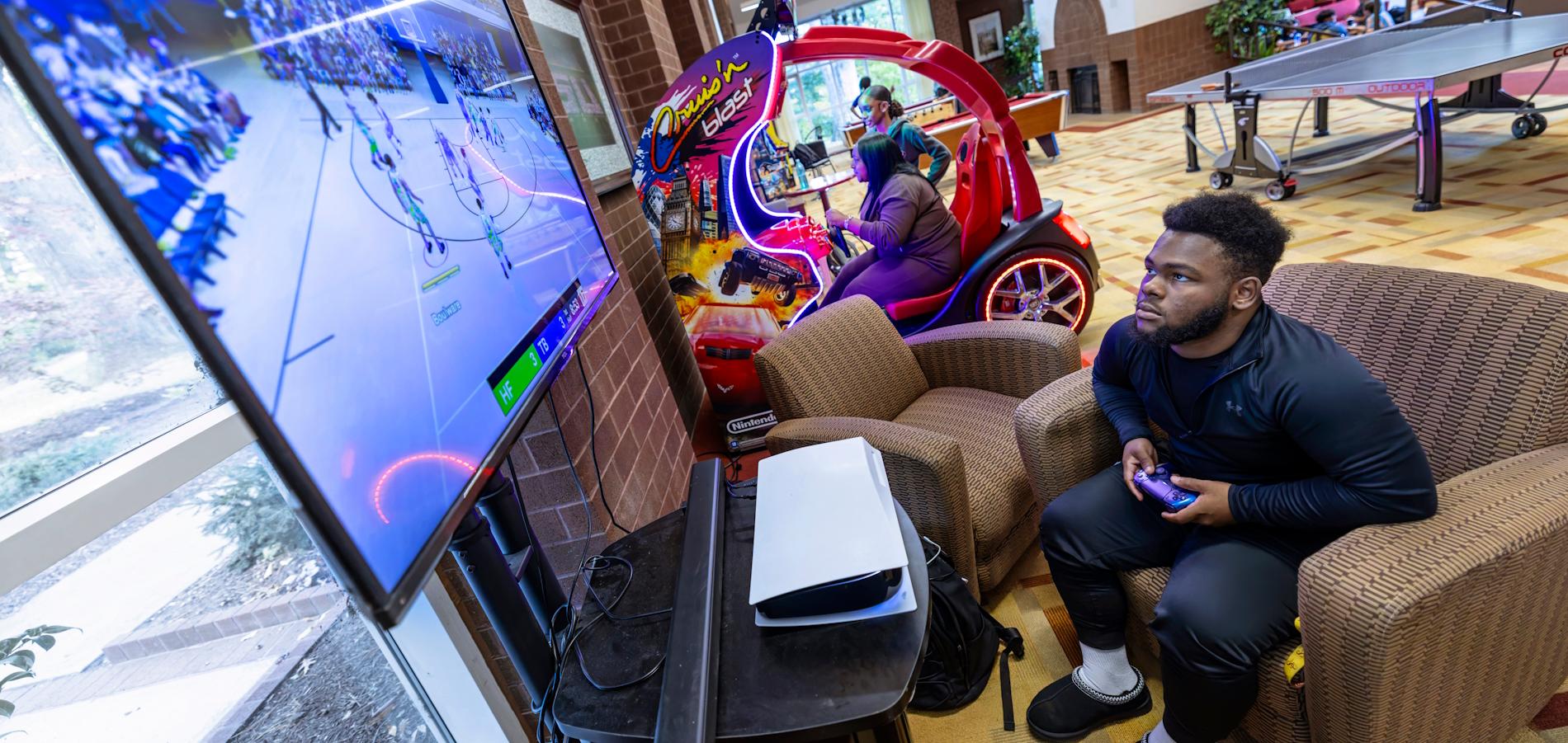 Student plays basketball game on TV inside the GAC