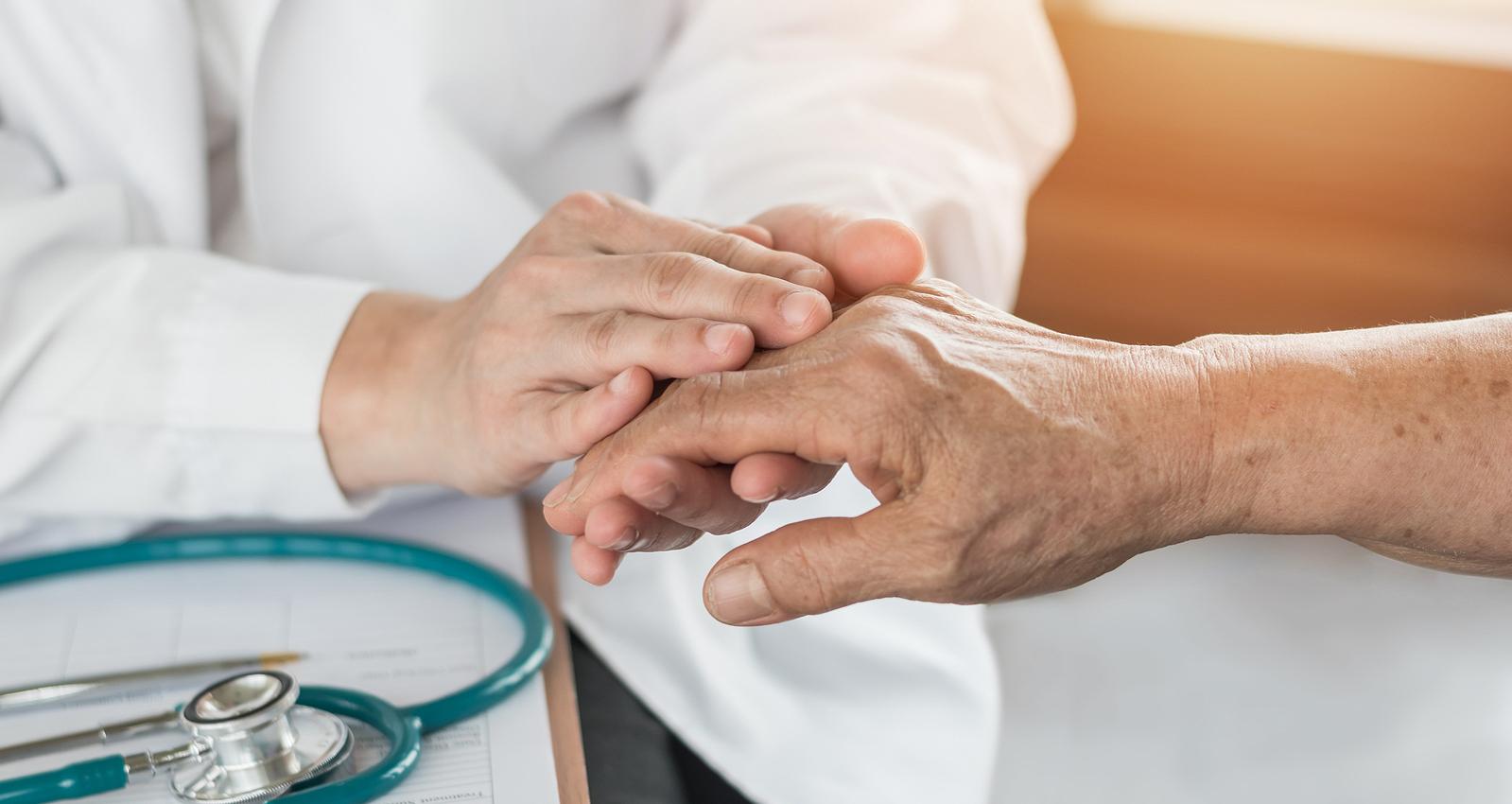 doctor holding elderly patient's hand