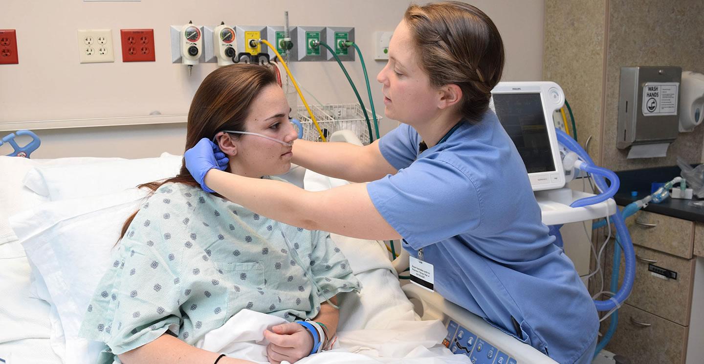 healthcare worker assisting a patient with oxygen supply tube