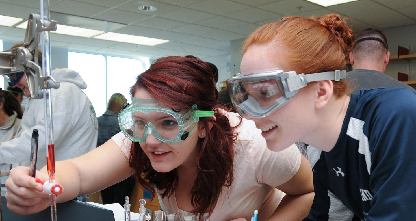 two students examining liquid in lab