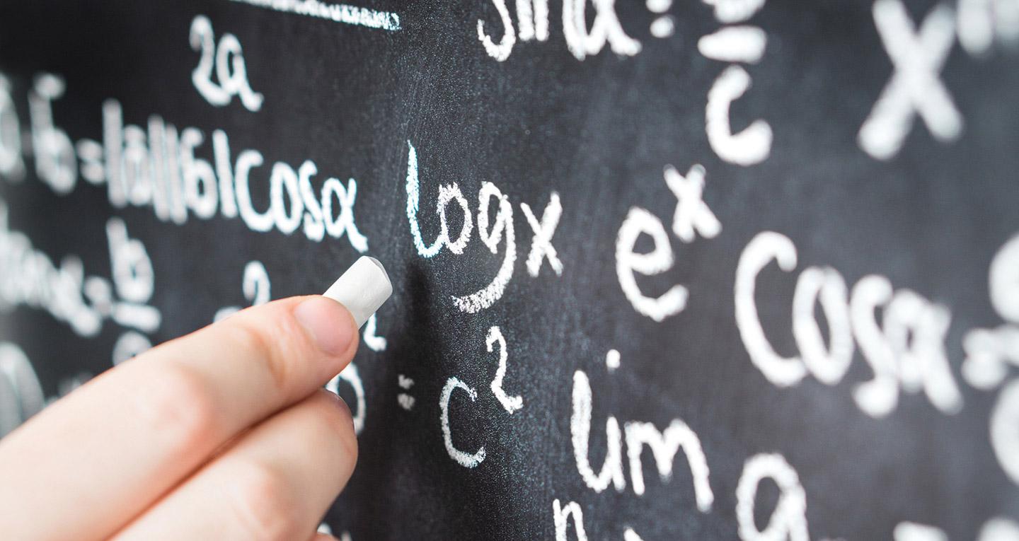 hand writing math equations on chalkboard
