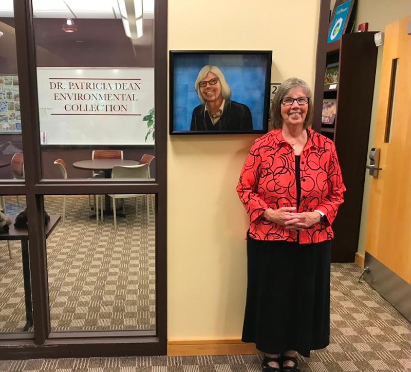 A beaming Dr. Dean aside her named collection and original collage portrait created by long-time friend, Eastern Shore native, and award-winning author/illustrator Bryan Collier.